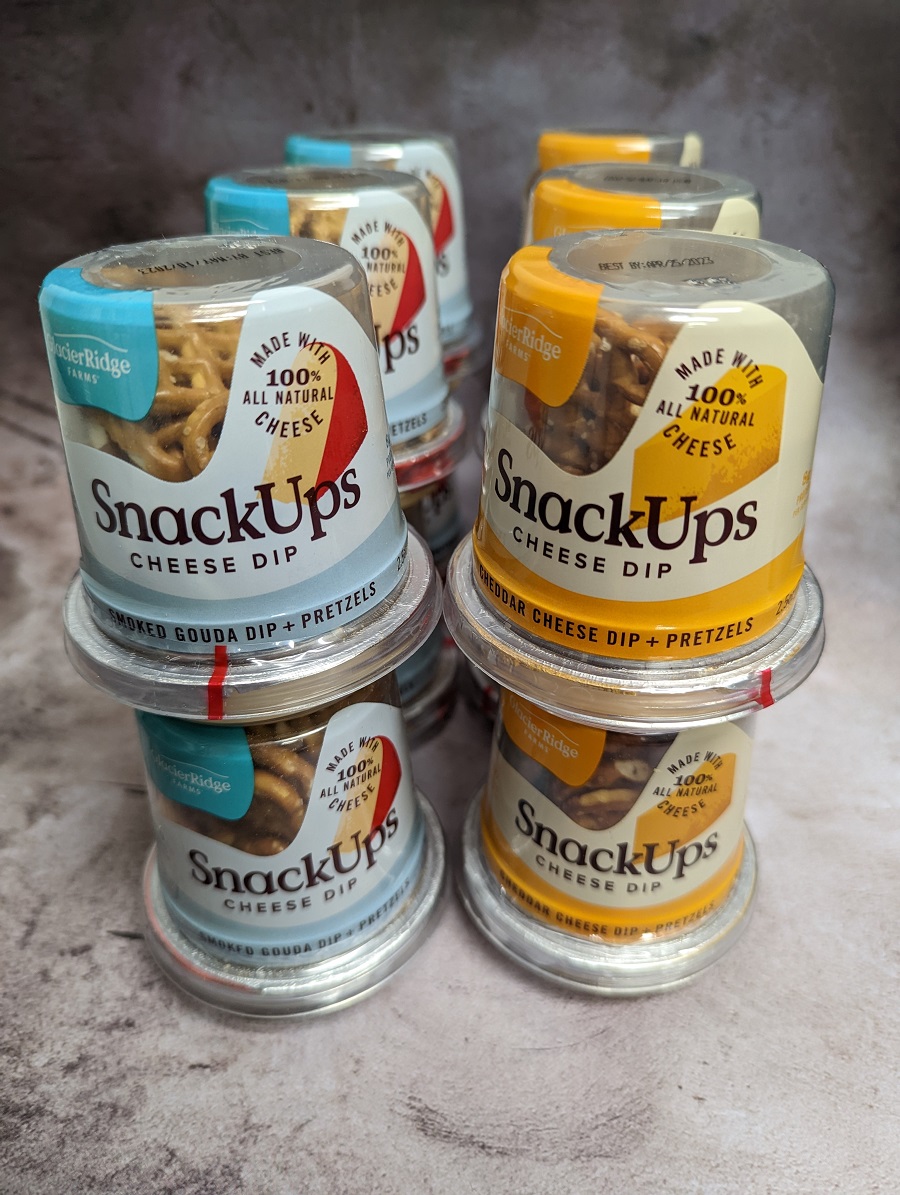 Grab and Go Snack Packs with cheese dip and pretzels ready to stock on shelves in many grocery stores, convenience stores, and online retailers. 